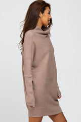 woman wearing a taupe oversized turtleneck sweater dress with long sleeves