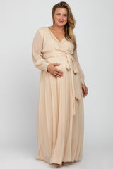 woman wearing a mauve long sleeve maternity dress with a wrap design and holding her baby bump
