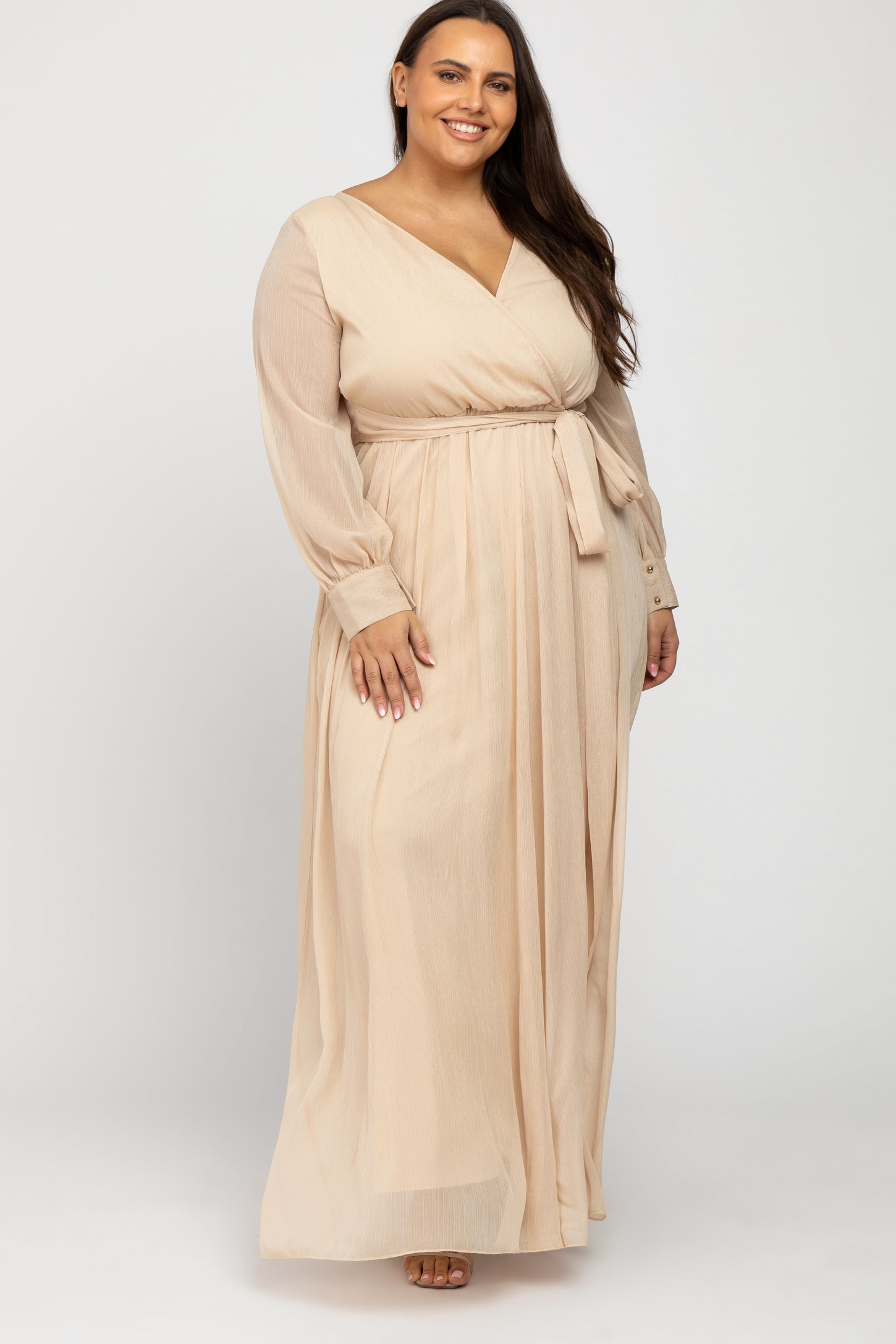 Plus size woman wearing a long sleeve beige wrap maxi dress with a waist tie