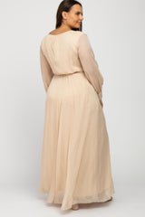 woman wearing a blush long sleeve plus size maxi dress with a cinched waist, shown from the back