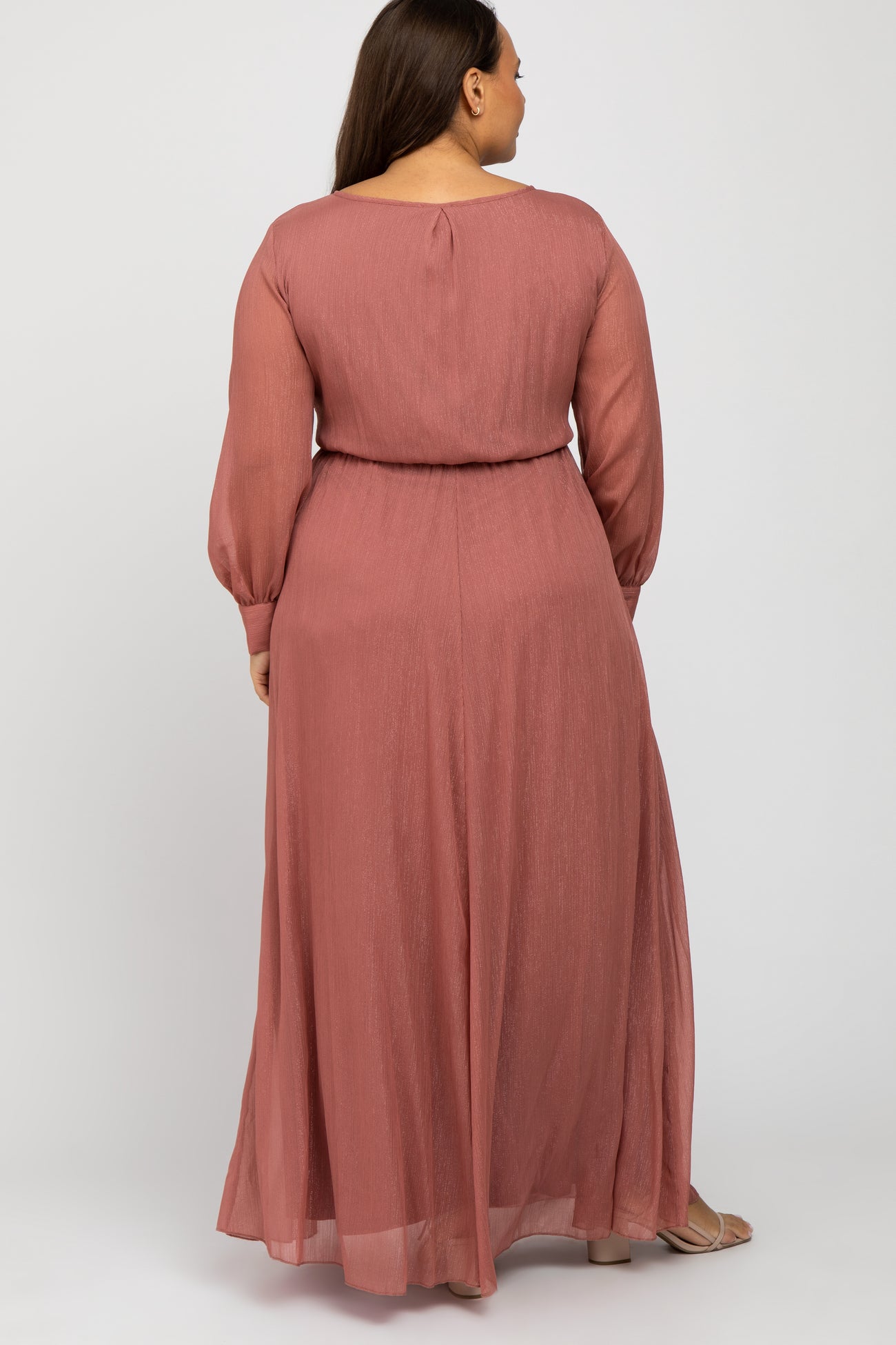 woman wearing a rose-colored long sleeve maxi dress with a cinched waist, seen from the back