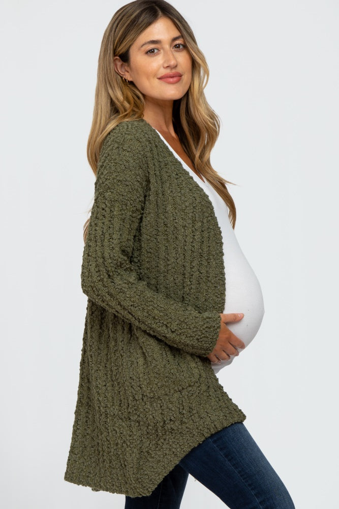 pregnant woman wearing olive green popcorn knit maternity cardigan and white top