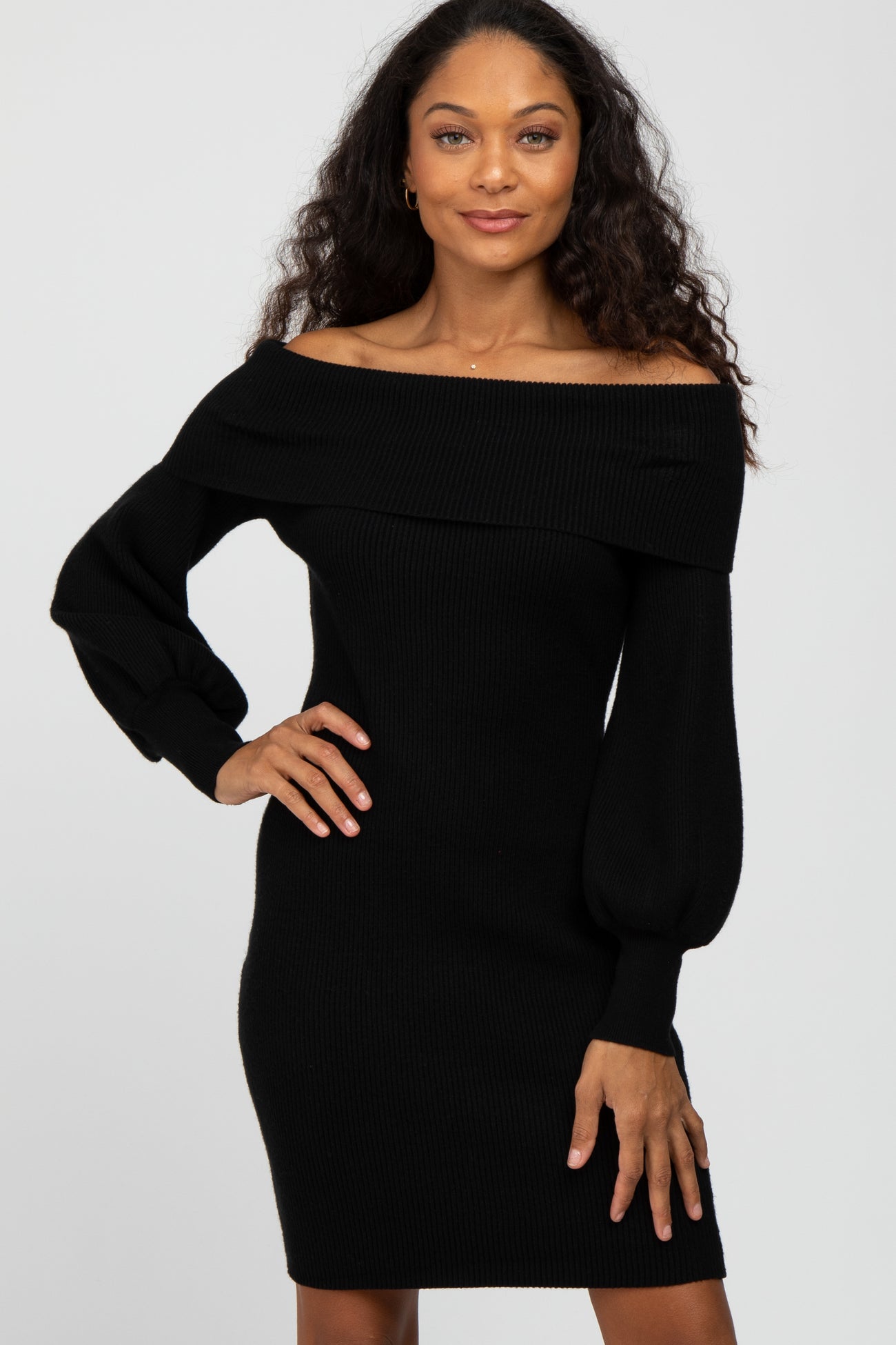 Woman wearing a black off-the-shoulder ribbed knit dress with long puff sleeves