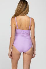 woman wearing a lavender maternity swimsuit with adjustable straps, showing the back view