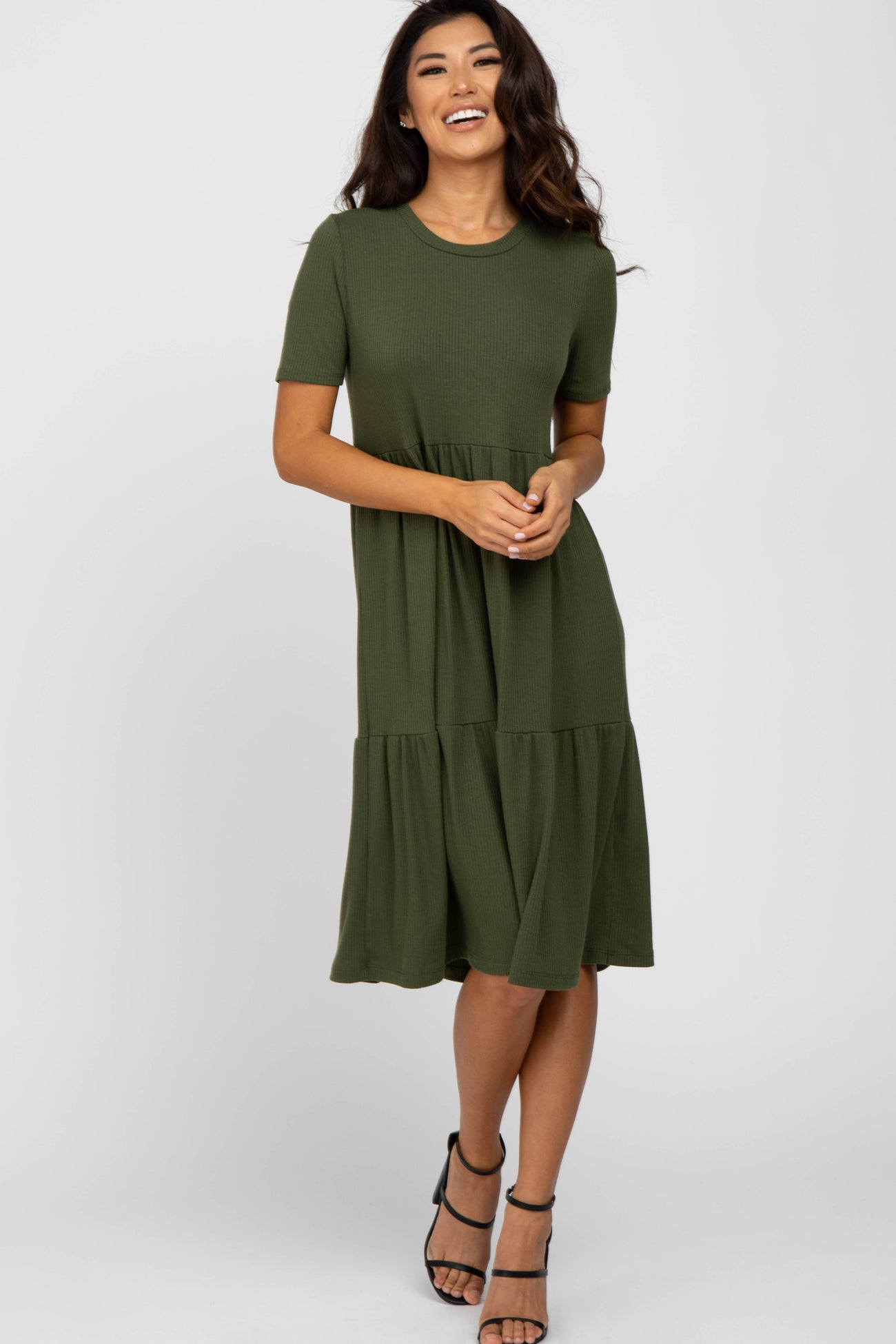 woman wearing an olive green short sleeve tiered midi dress with a scoop neckline and a flared skirt