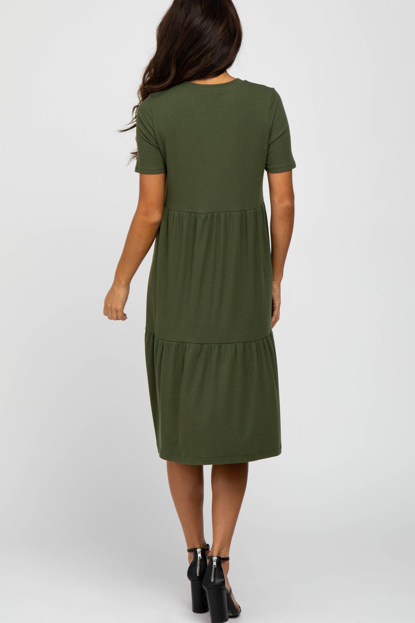 woman wearing a green tiered midi dress with short sleeves, shown from the back