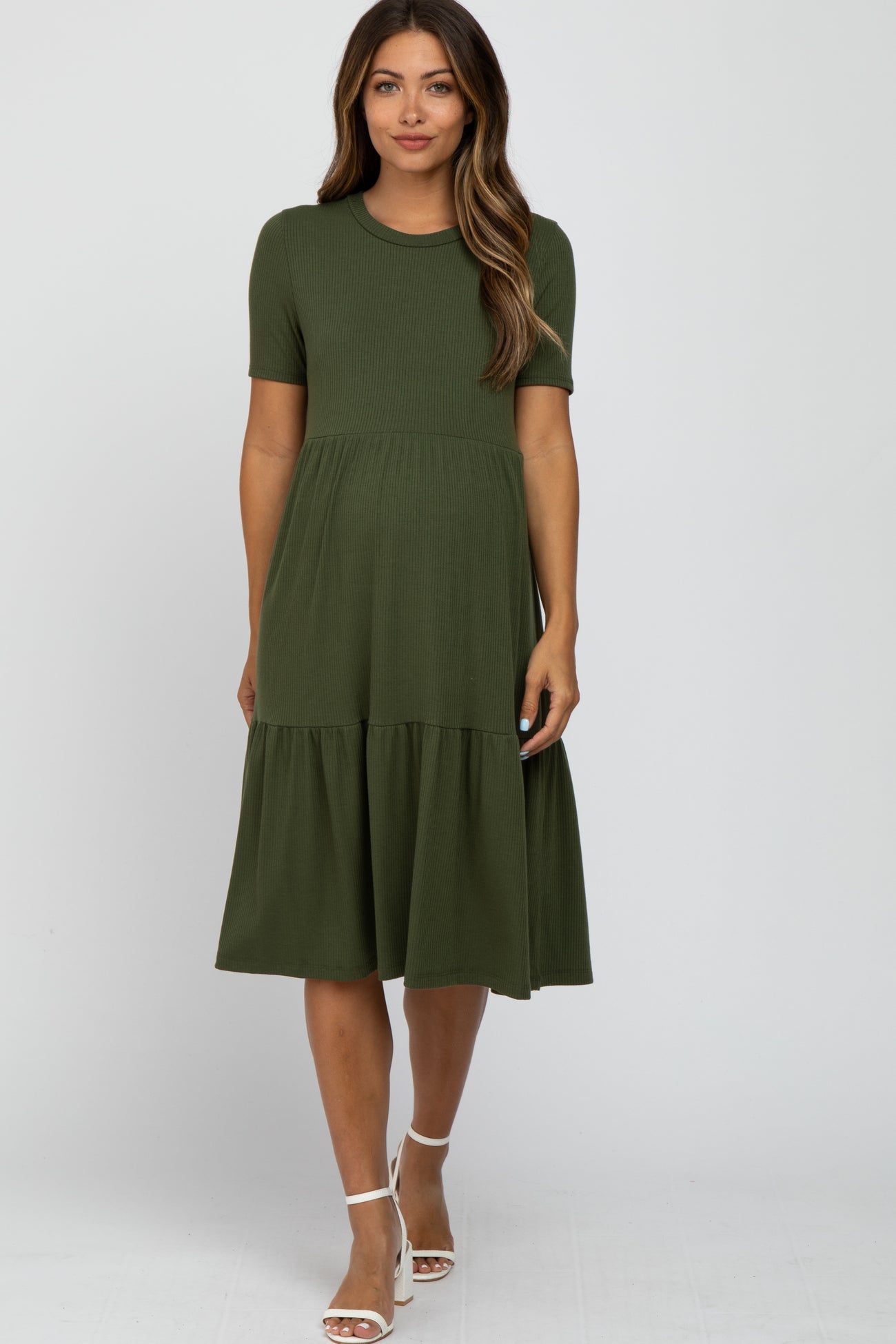 woman wearing an olive green short sleeve maternity dress with a tiered skirt