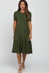 woman wearing an olive green short sleeve maternity dress with a tiered skirt