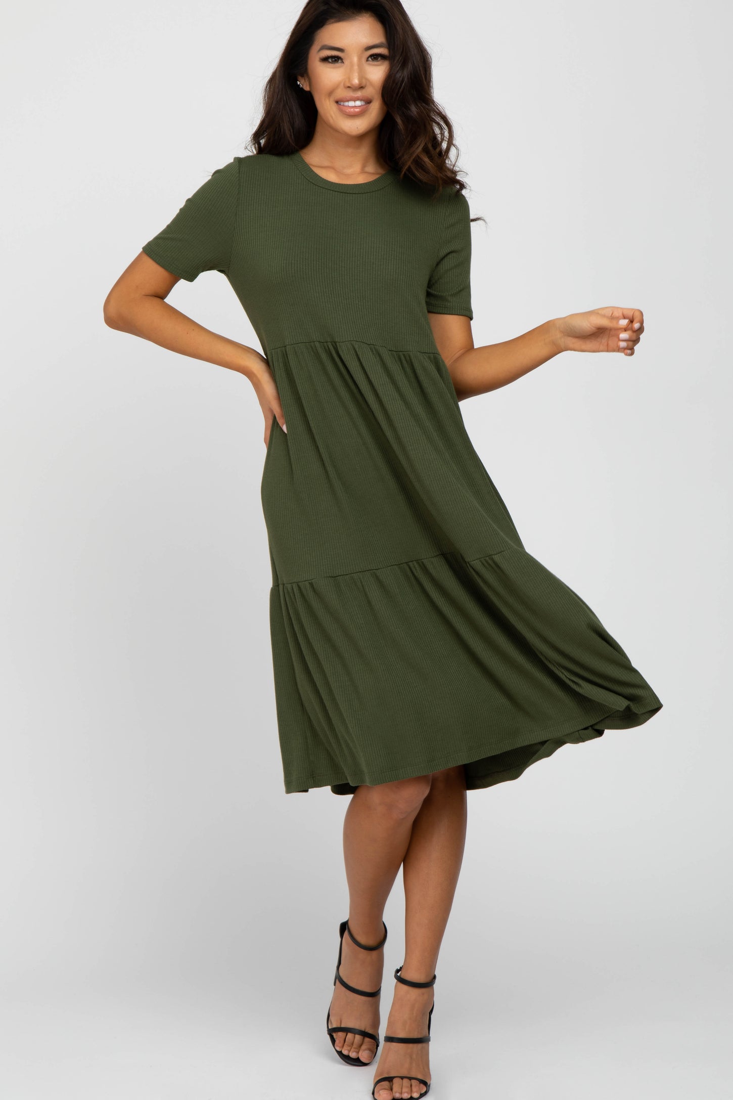 woman wearing olive green short sleeve tiered ribbed midi dress and black strappy heels