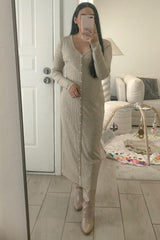 woman in beige ribbed button-down maxi dress and matching boots taking a mirror selfie in a living room