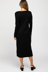 Back view of a woman wearing a long sleeve black ribbed midi dress and black block heel sandals