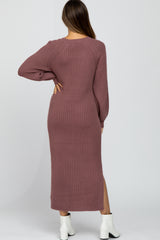 woman wearing a mauve long sleeve ribbed maternity dress with a side slit and fitted silhouette