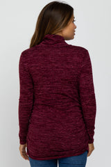 woman wearing a burgundy long sleeve maternity sweater with a cowl neck and side ruching