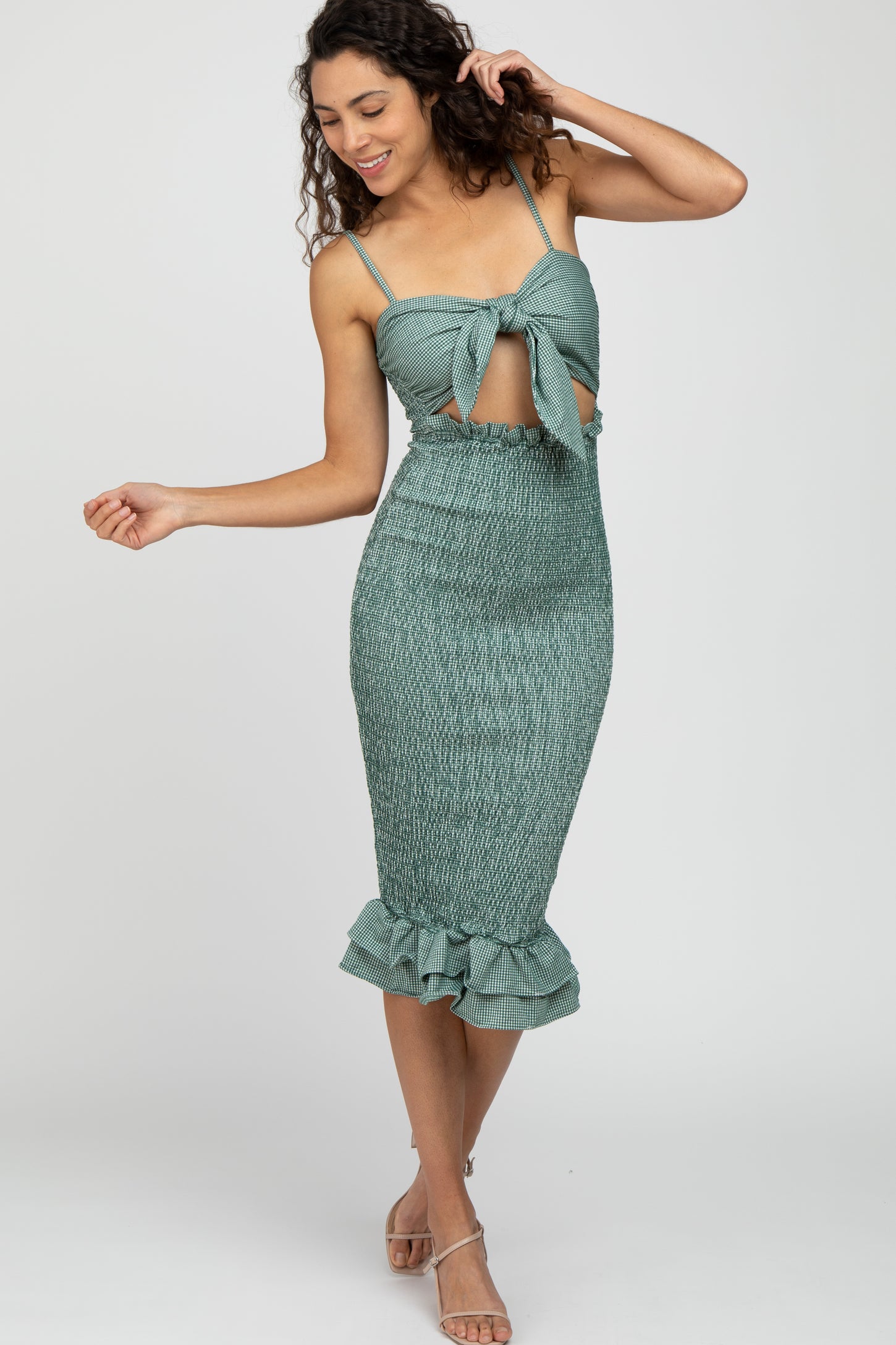 woman wearing a teal smocked midi dress with a tie front and ruffled hem