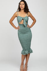 woman wearing a teal smocked two-piece dress with a knotted crop top and ruffled hem skirt
