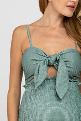 woman wearing a green and white gingham maternity crop top with a front tie and ruffle detailing