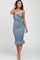 woman wearing a blue smocked midi dress with a knot detail and ruffled hem, posing and smiling