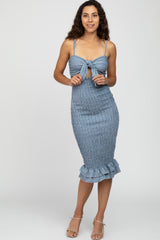 woman wearing a blue and white gingham smocked midi dress with a tie front and ruffle hem