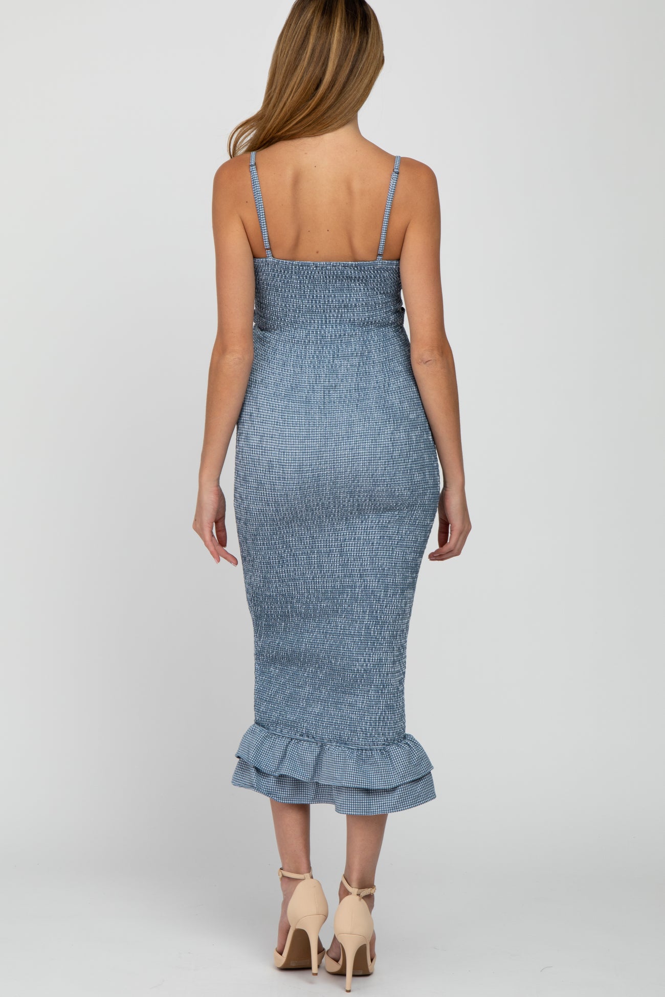 woman wearing a light blue maternity dress with a fitted silhouette and ruffled hem, viewing from the back