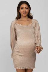 woman wearing a beige maternity dress with smocked body and satin balloon sleeves, showcasing her baby bump