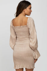 woman wearing a champagne smocked bodycon dress with long puff sleeves and a square neckline