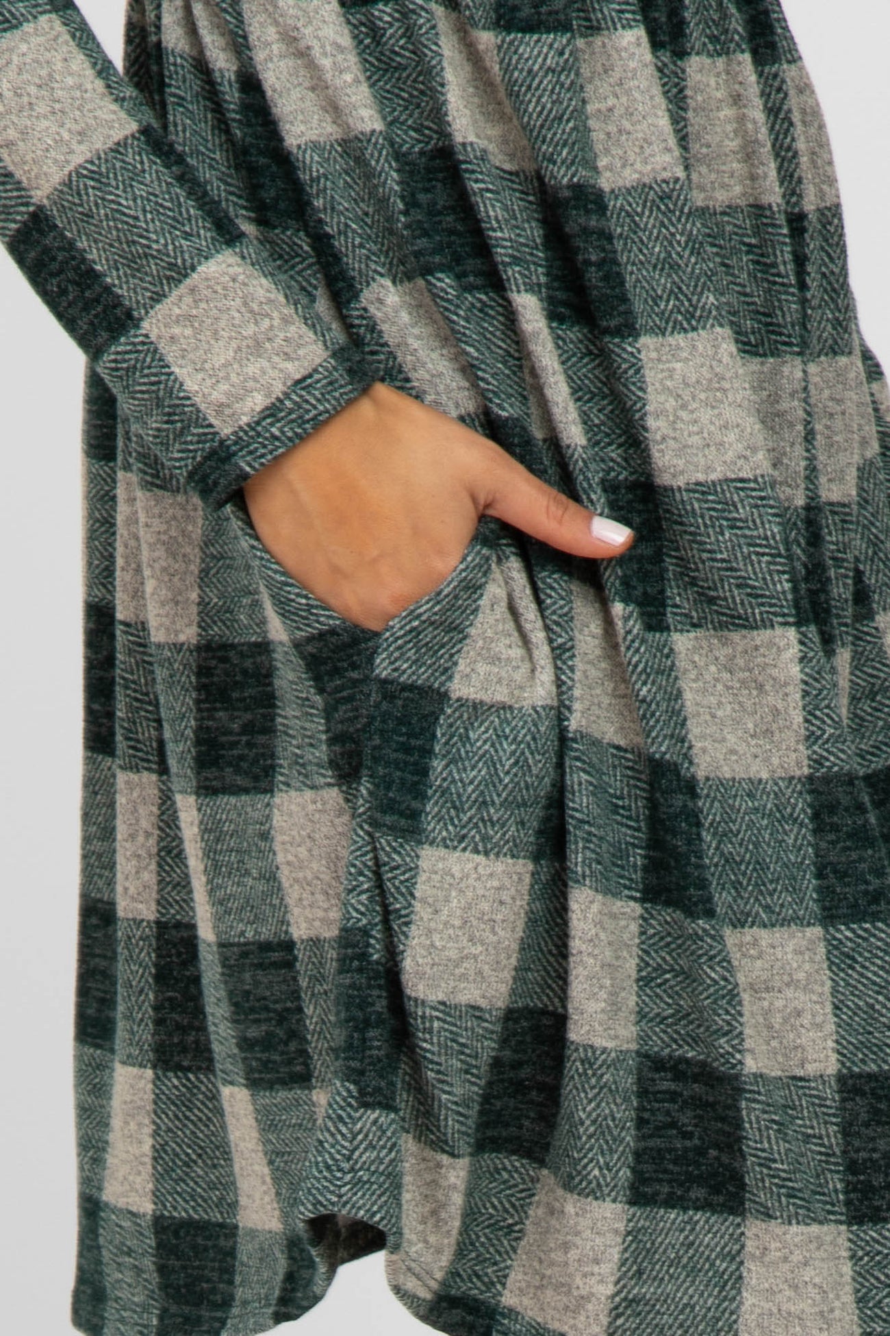 woman wearing a green and beige checkered oversized dress with long sleeves and side pockets