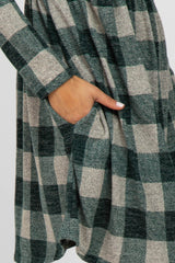 woman wearing a green and beige checkered oversized dress with long sleeves and side pockets