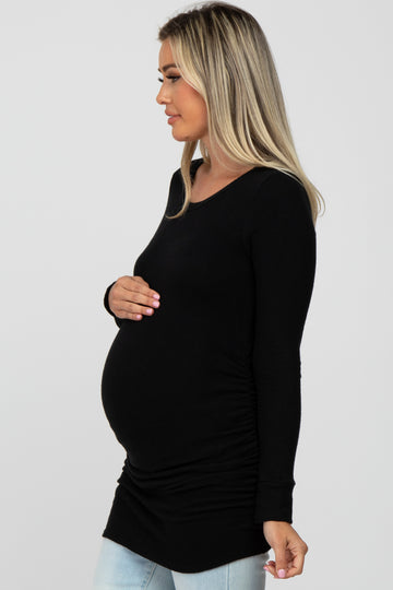 woman wearing a black long sleeve maternity top with side ruching and a visible baby bump