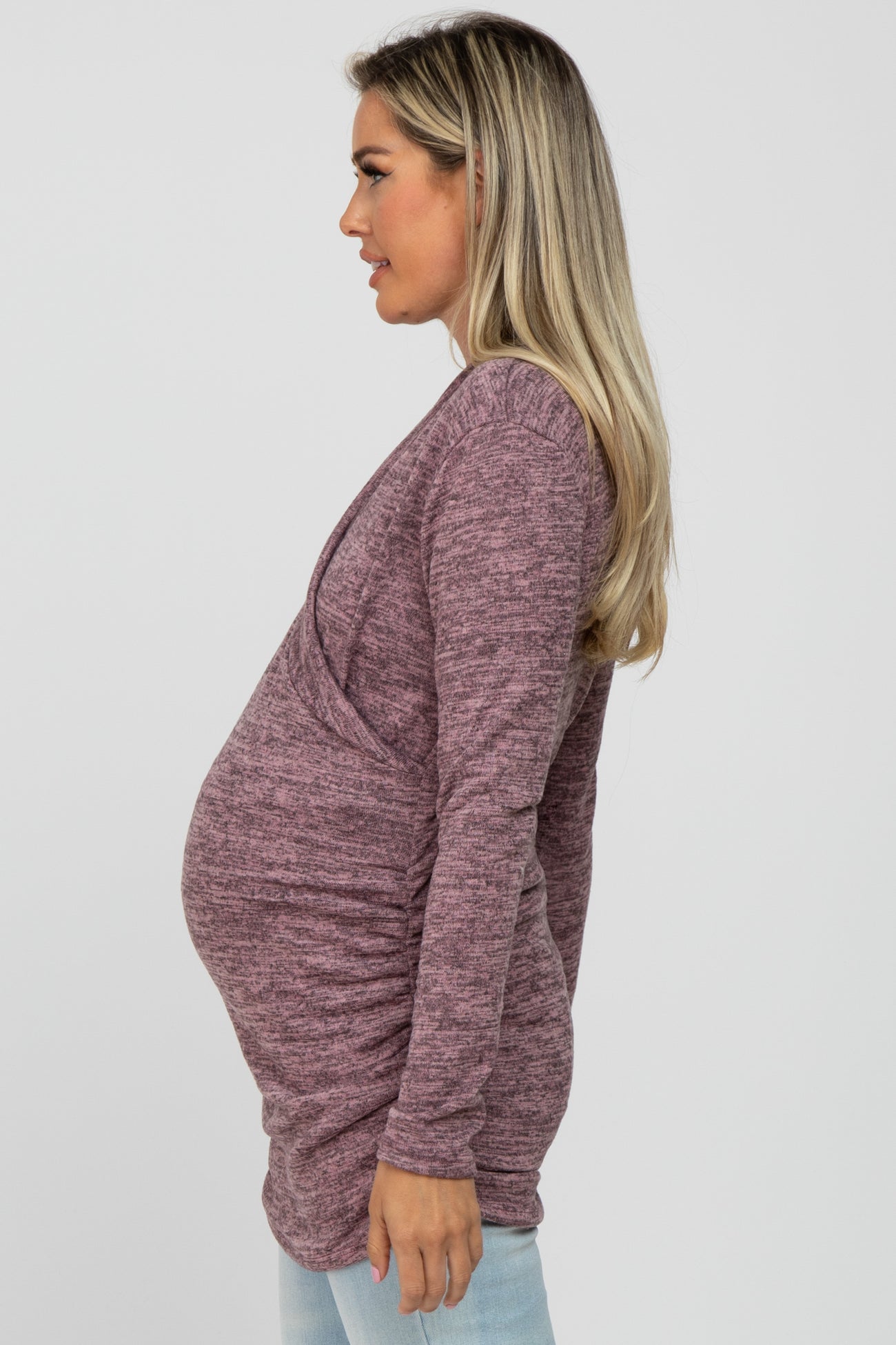 woman wearing a maroon maternity top with a v-neck and ruched sides, showing her baby bump