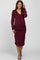 woman wearing a burgundy long sleeve maternity dress with a v-neck and ruched sides, showing her baby bump