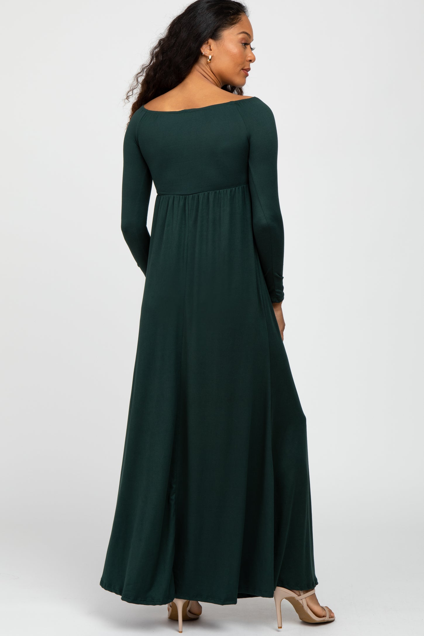 woman wearing a dark green long sleeve maxi dress, showing a flowy silhouette from the back