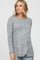 blonde woman wearing a grey long sleeve marled knit top and light wash jeans