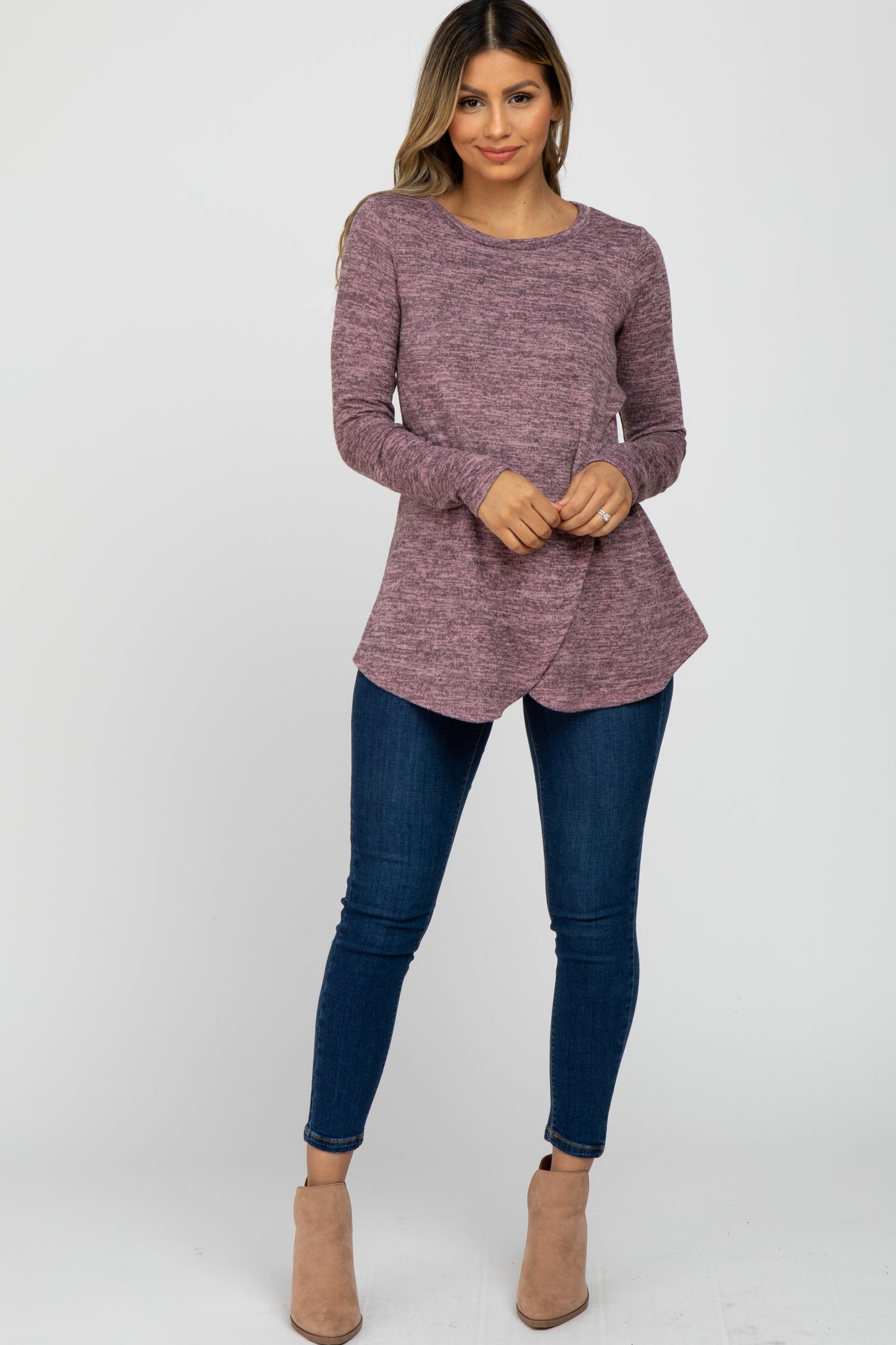woman wearing a mauve long sleeve tulip hem maternity top with dark blue skinny jeans and tan ankle boots