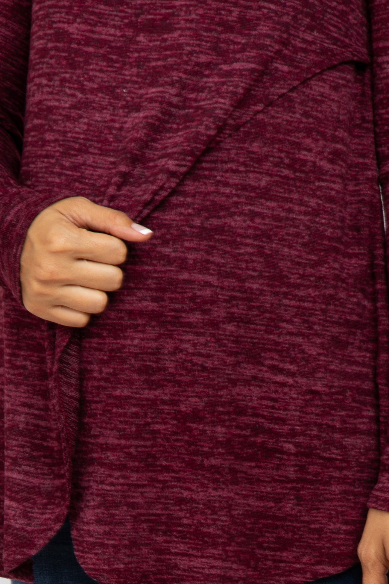 close up of a person wearing a burgundy marled knit wrap cardigan with draped front detail