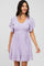woman wearing a light purple short dress with flutter sleeves and a ruffled hem
