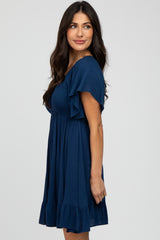 woman wearing a navy blue short sleeve dress with ruffle details and a fitted bodice