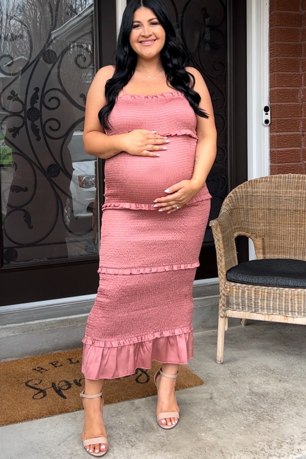 woman wearing a dusty rose maternity maxi dress with ruffles and holding her baby bump