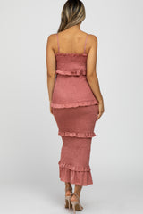 Back view of a woman wearing a mauve smocked tiered maternity maxi dress with ruffle details and spaghetti straps