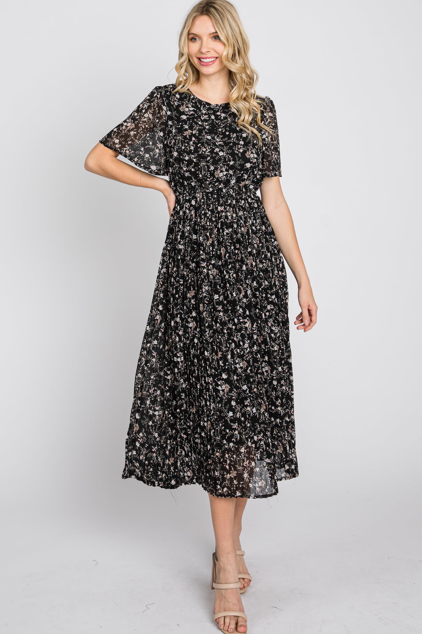 woman wearing a black floral midi dress with short sleeves and a smocked bodice