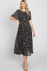 woman wearing a black floral midi dress with short sleeves and a smocked bodice