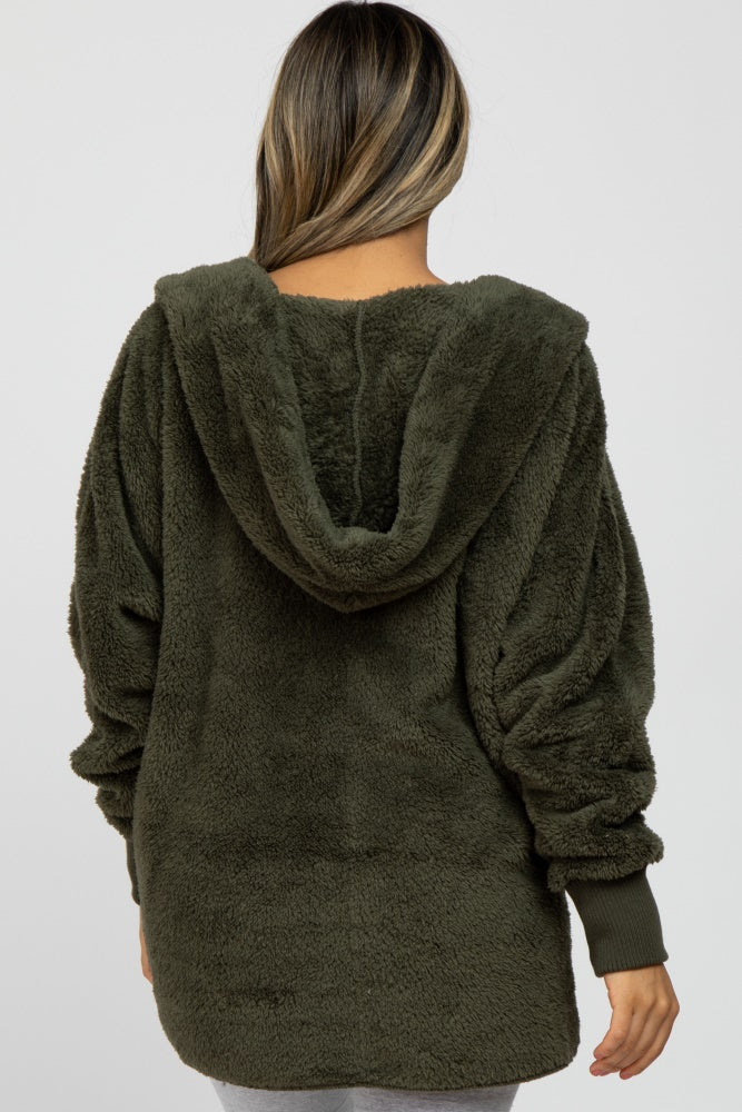 back view of a woman wearing an olive green fuzzy sherpa hooded jacket with ribbed cuffs