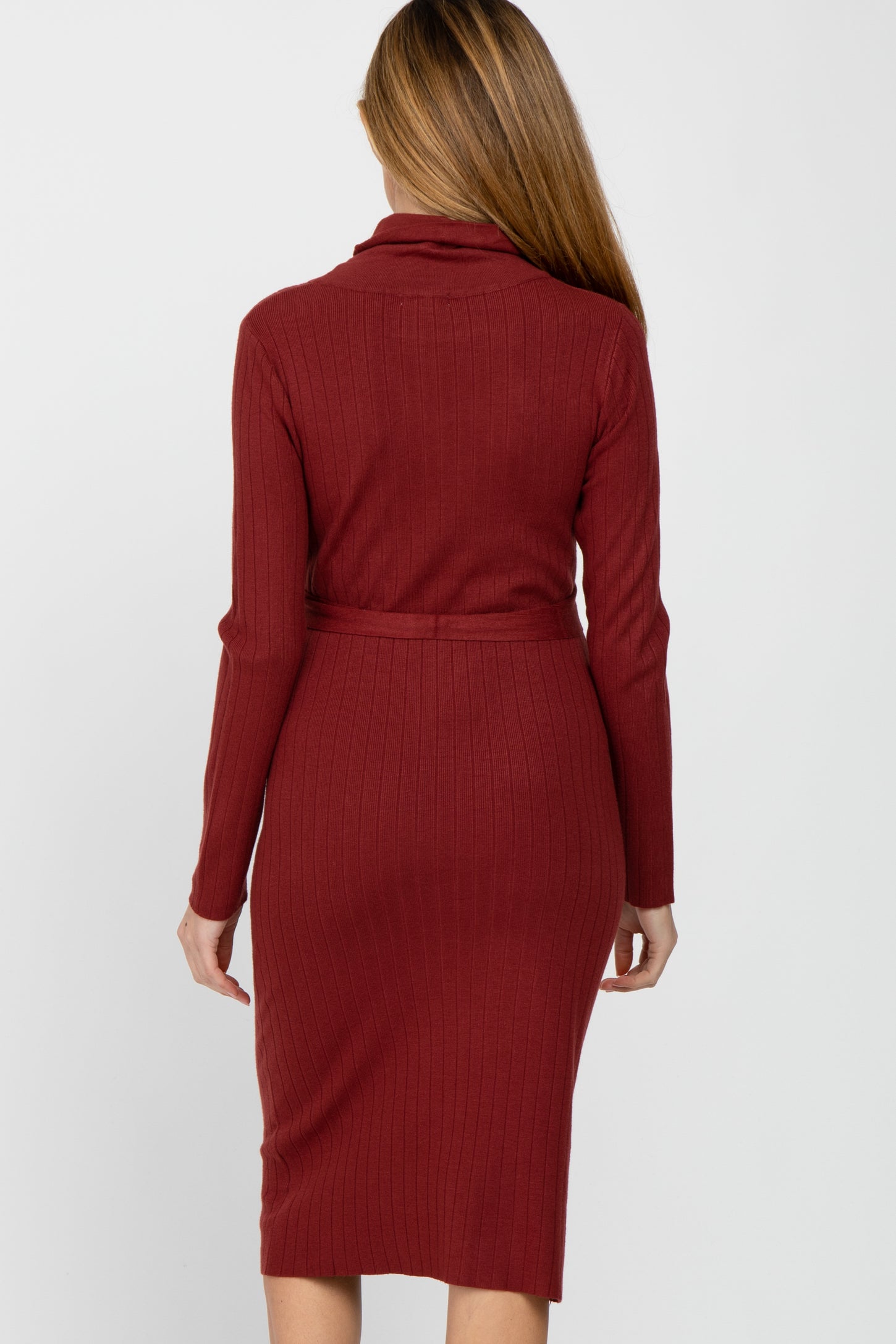 Back view of a woman wearing a long-sleeved ribbed knit midi dress in burgundy with a matching waist tie