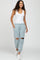woman wearing white tank top and light blue distressed joggers with knee cutouts and white sneakers