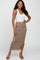 woman wearing white tank top and leopard print midi skirt with side slit and brown heels