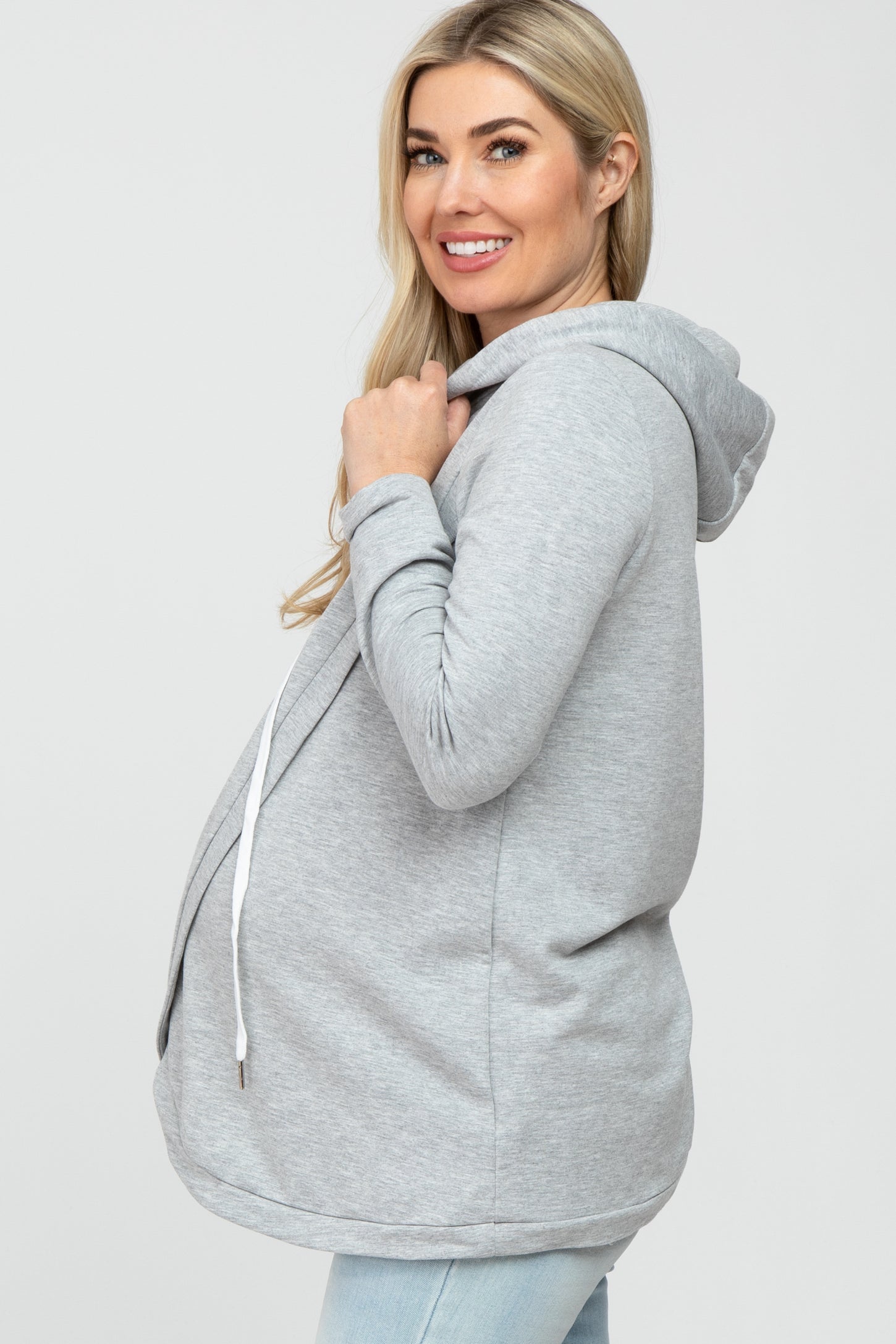 woman wearing a gray maternity hoodie with a front pocket and adjustable drawstring, showing her baby bump