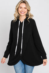 woman wearing a black oversized hoodie with white drawstrings and a flowy hem, paired with blue jeans