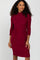 woman wearing a burgundy long sleeve dress with a fitted bodice and pleated skirt details