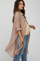 woman wearing a light taupe maternity tunic shirt with rolled sleeves and a visible baby bump