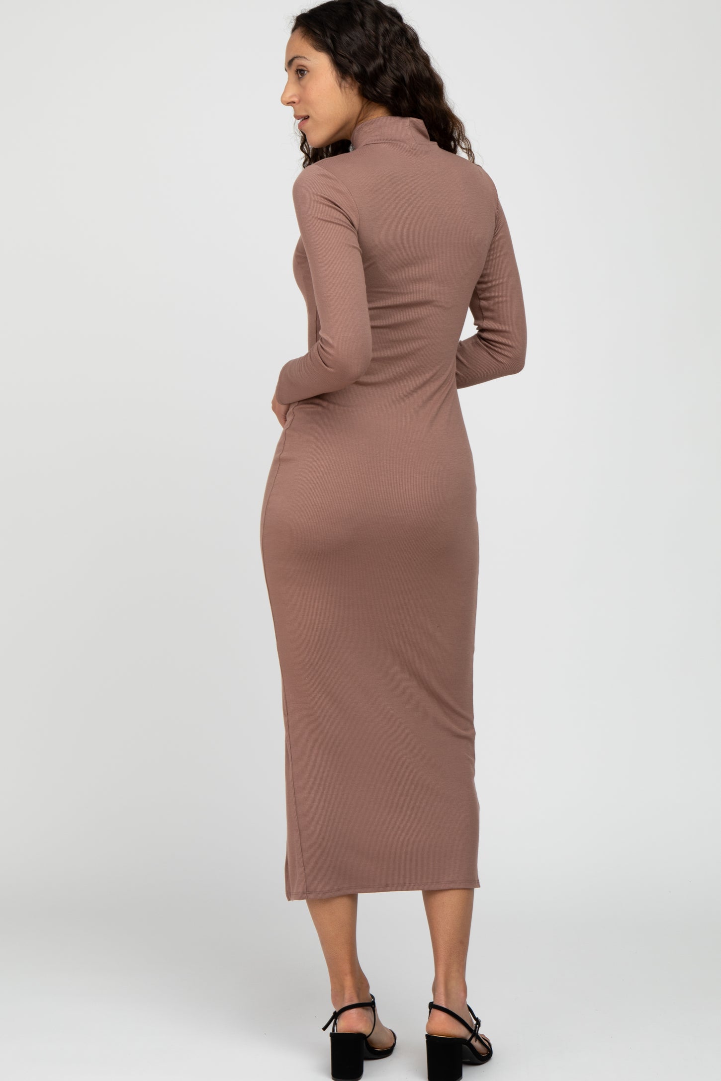 woman wearing a long sleeve mauve ribbed midi dress with a mock neck and black heels