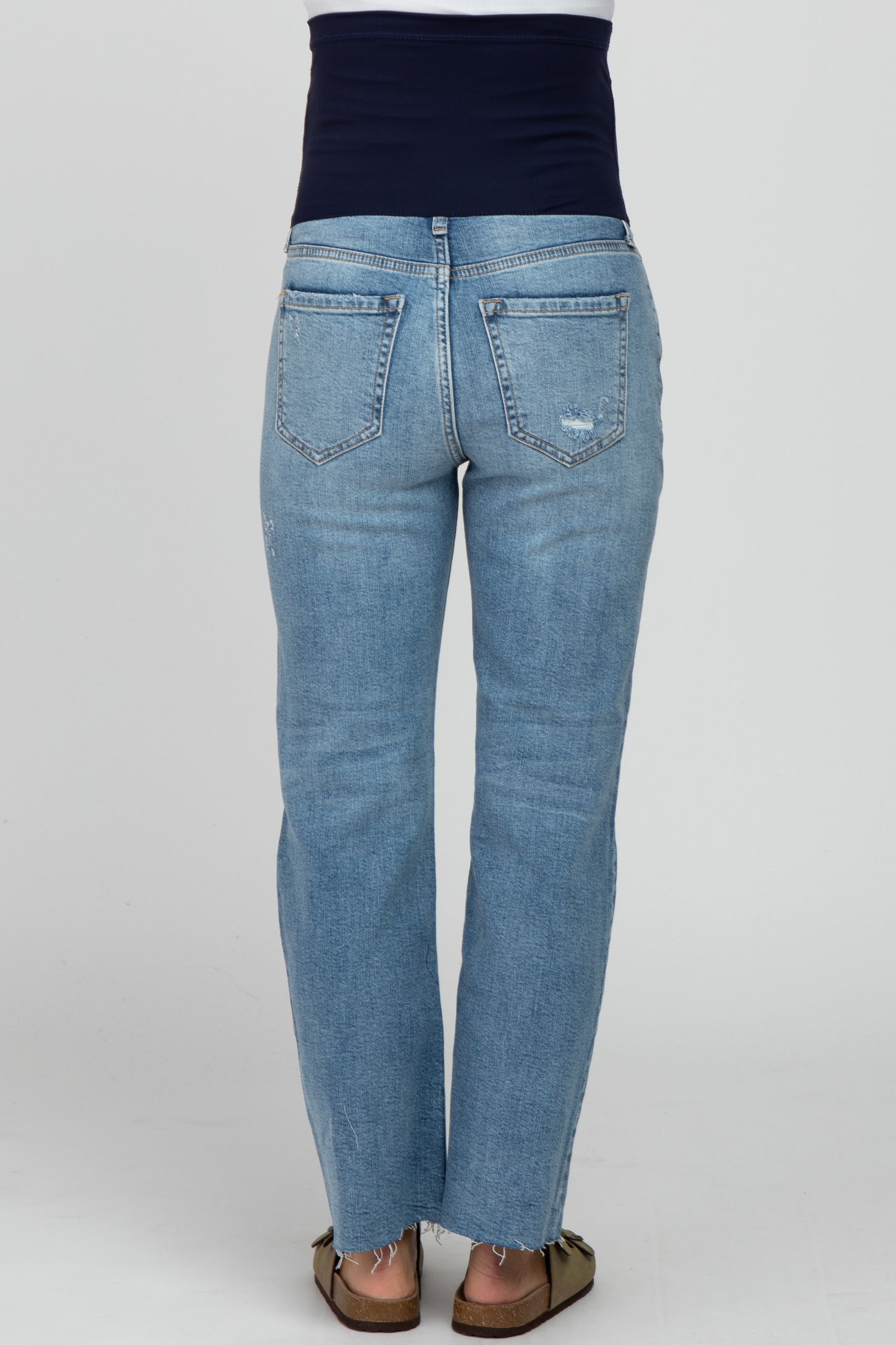 woman wearing light blue maternity jeans with a navy blue belly panel, showing the back view